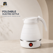 A white foldable electric kettle with a curved handle and a red power button, shown on a light beige countertop with a soft neutral background. Text on the left reads 'FOLDABLE ELECTRIC KETTLE' with a small MARTEK logo in the top left corner.