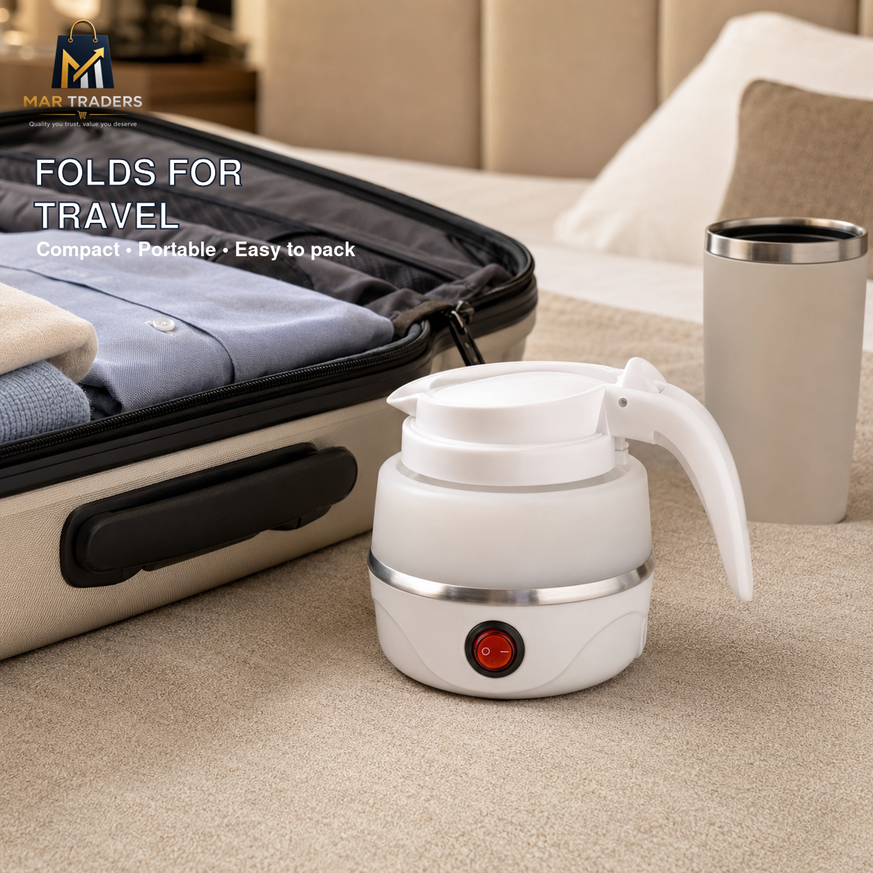 A white portable electric kettle with a handle and power button, shown next to an open suitcase and a travel tumbler on a beige carpet. Text on the image reads 'FOLDS FOR TRAVEL' and shows the MAR TRADERS logo.