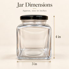 A clear square glass jar with a black lid on a light beige background, with dimension arrows and text showing approximate size as 4 inches height by 3 inches width.