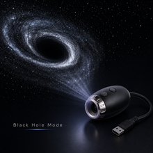A black portable projector with a USB cable, shown on a dark background projecting a swirling galaxy image. Text on the image reads 'Black Hole Mode'.