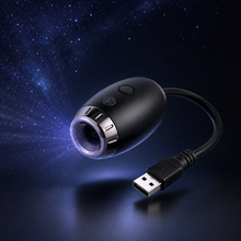 A black USB mini camera with a USB connector cable, shown floating against a dark starry space background with blue light rays emanating from the lens.