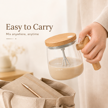 Portable self-stirring glass coffee mug being carried by its handle